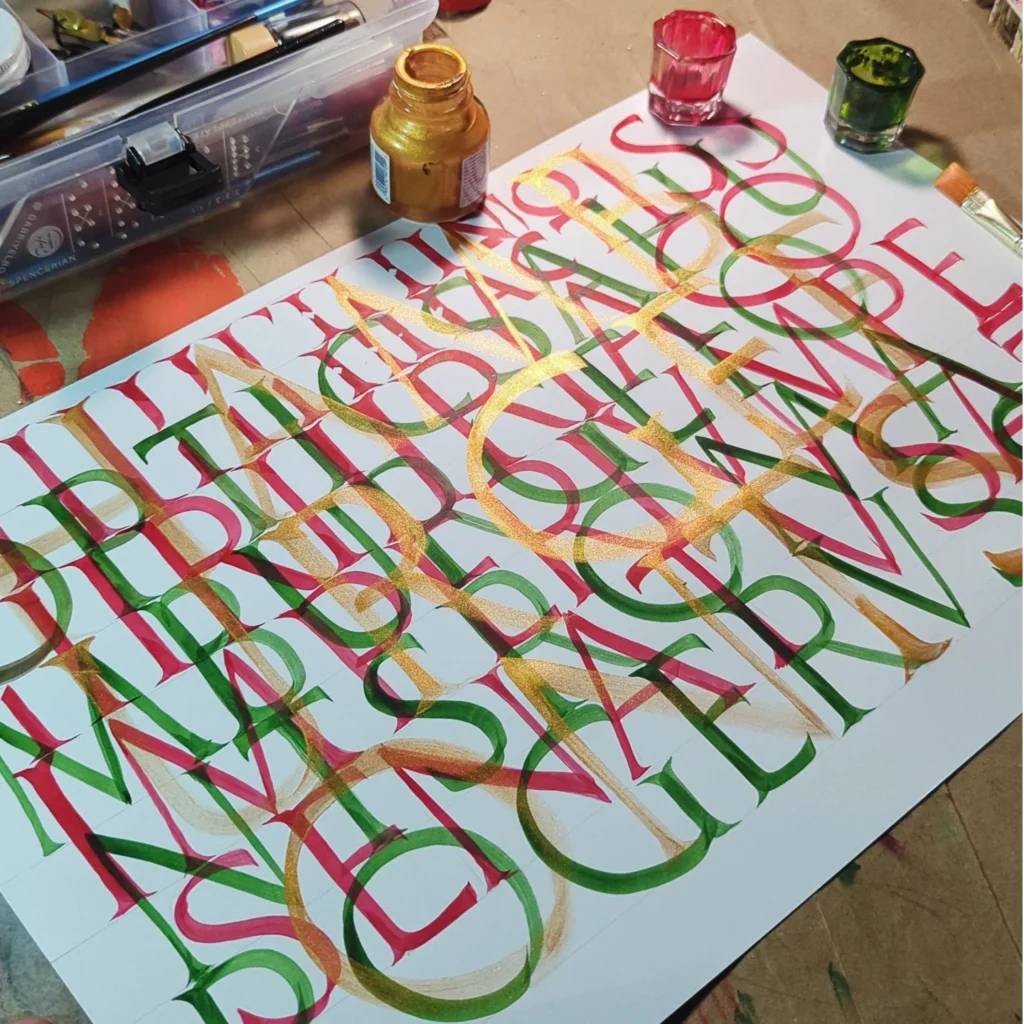 Capitulares romanas en caligrafía con tintas roja, verde y dorada