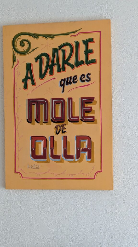 Letrero pintado a mano: A darle que es mole de olla