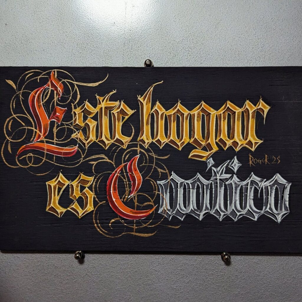 Letrero pintado a mano con detalles dorados: Este hogar es católico