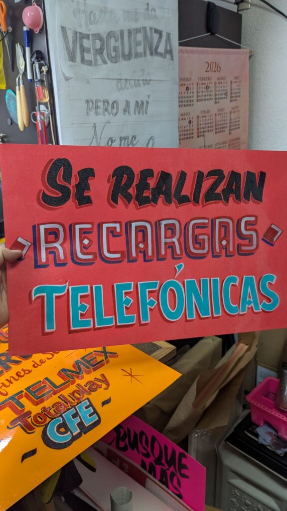 Letrero pintado a mano en un comercio: Se realizan recargas telefónicas
